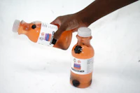a person holding a bottle of orange juice