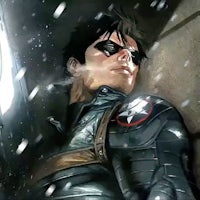 a man in a black suit is laying in the snow