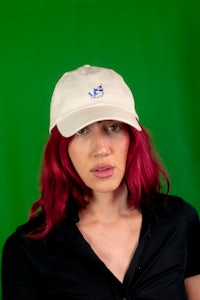 a woman with red hair wearing a hat