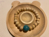 a wooden bracelet with a turquoise bead on it