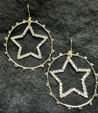 a pair of gold star shaped hoop earrings