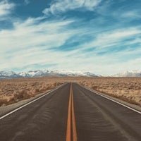 an empty road with mountains in the background