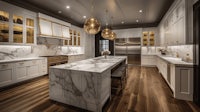 a white kitchen with marble counter tops and gold pendant lights
