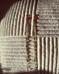 a pair of earrings sitting on top of a pillow