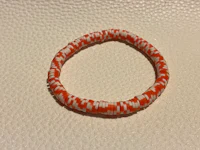 an orange and white striped bracelet on a table