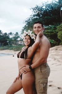 a man and woman posing for a photo on the beach