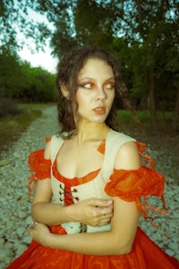 a woman in a red dress posing on a path