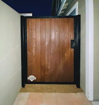 a wooden gate with a black metal frame
