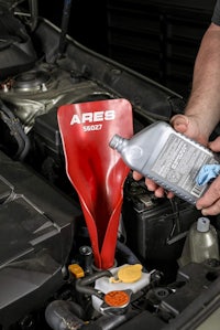 a man pouring oil into the engine of a car
