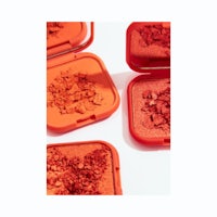 a set of red eyeshadow compacts on a white surface