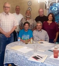 a group of people standing around a table