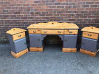 a grey painted desk with two drawers and two drawers