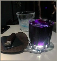 a purple drink and a cigar on a table