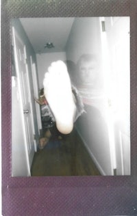 a polaroid of a person's foot in a hallway