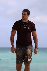 a man wearing a t-shirt and shorts on the beach