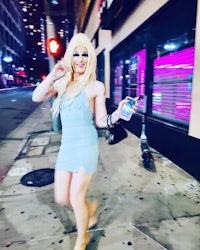 a woman in a blue dress walking down the street