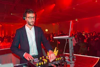 a man in glasses playing a dj at an event
