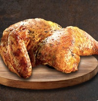 a chicken is sitting on a wooden cutting board