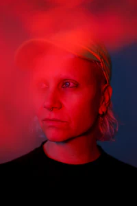 a man in a hat with red smoke in front of him