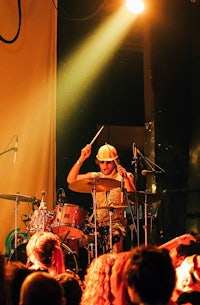 a man playing drums in front of a crowd of people