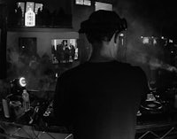 a black and white photo of a dj in front of a crowd