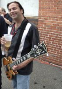 two men standing next to each other holding guitars