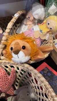 stuffed animals in baskets on a shelf