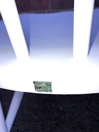 a close up of a white chair with a sticker on it