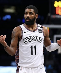 the brooklyn nets player is holding his hands up in the air