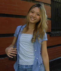 a blond woman wearing a blue polka dot shirt and jeans