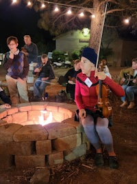 a group of people sitting around a fire pit
