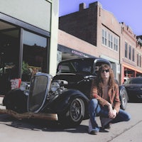 a man crouching in front of a car