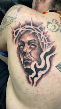 a man with a tattoo of jesus on his back