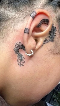 a woman with a dragon tattoo on her ear