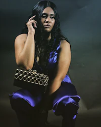 a woman in a purple jumpsuit posing for a photo