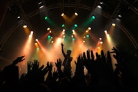 a concert with people raising their hands in the air