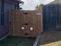 a wooden gate with two holes in it
