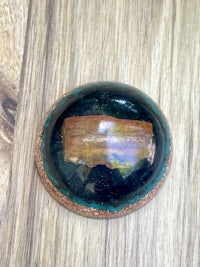 an oval shaped stone on top of a wooden table