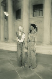 two women standing in front of a building