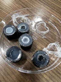 a plastic bowl filled with black and white ice cubes