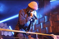 a man in a hat is singing into a microphone