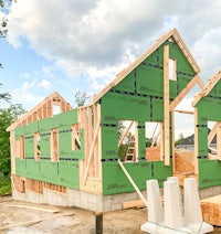 a house under construction with green framing