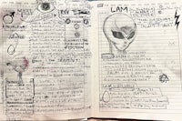 a notebook with a drawing of an alien on it
