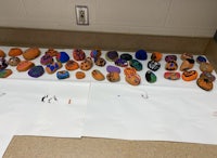 a group of painted rocks on a white sheet of paper