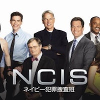 a group of people posing in front of a poster for ncis