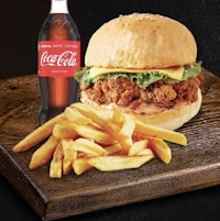 a chicken burger with fries and a coca cola bottle
