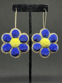 a pair of blue and yellow flower earrings