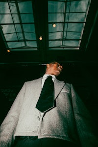 a man in a suit looking up at the sky
