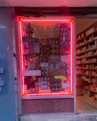 a store with a red neon sign in front of it