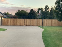 a backyard with a basketball hoop and a wooden fence